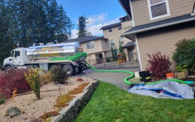 Septic system maintenance truck with company logo parked at a residential property